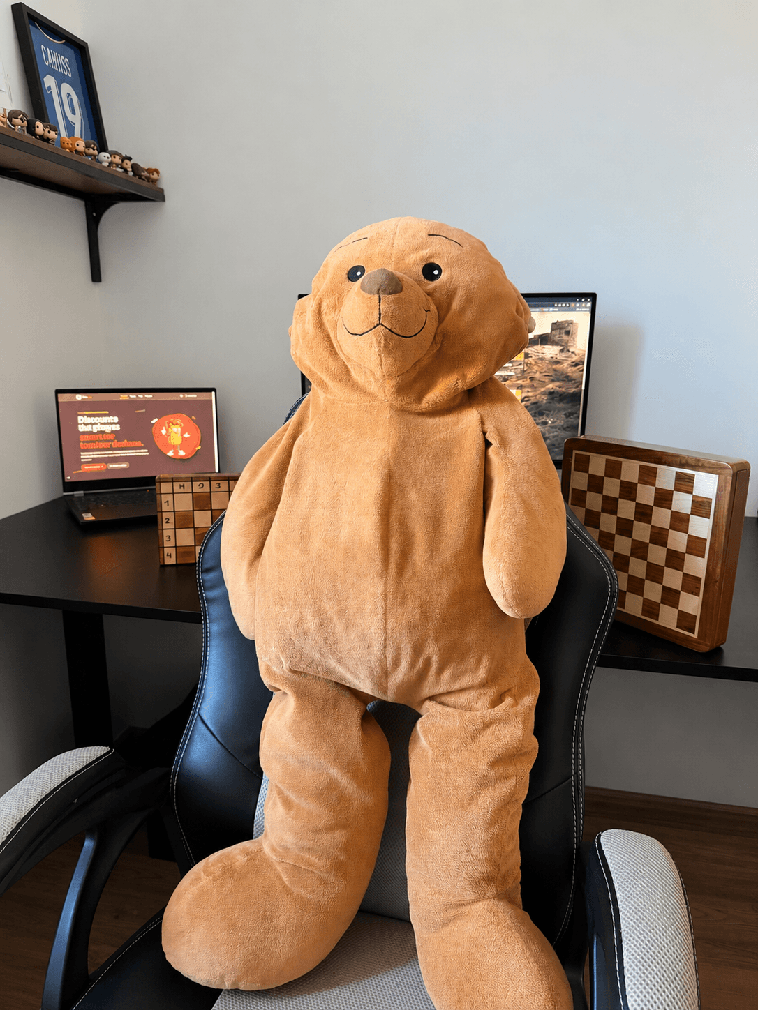 La peluche TrapMate devant l’espace de travail du projet et un échiquier